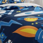 Bright space-themed bed linen featuring planets, stars, rockets, and astronauts, perfect for children's bedrooms and educational decor.