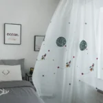Whimsical space-themed nursery curtain with planets and rockets for kids' room decoration.