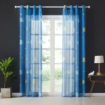 Bright blue sheer curtains with moon and star patterns, ideal for children's bedrooms or playrooms, adding a whimsical touch to the decor.