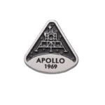 Metal badge featuring the Apollo 11 lunar module with "APOLLO 1969" inscription, commemorating the first moon landing in 1969.