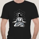 Black T-shirt featuring a detailed illustration of a space explorer astronaut sitting cross-legged with a geometric pattern background, perfect for science and space enthusiasts.