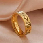 Elegant gold ring engraved with space-themed symbols including planets, stars, and moons, resting on soft satin fabric. Perfect for astronomy enthusiasts and as a unique jewelry piece.