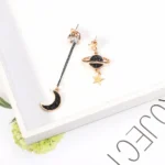 Elegant celestial-themed earrings featuring a crescent moon and a planet with a star charm, perfect for space lovers.