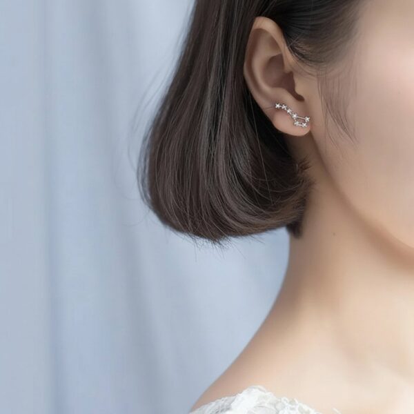 Elegant star constellation ear cuff jewelry on a woman's ear, showcasing delicate celestial design.