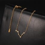 Delicate gold chain necklace featuring a V-shaped pendant adorned with sparkling diamonds, perfect for adding a touch of sophistication to any outfit.