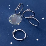 Elegant galaxy-themed jewelry featuring three silver rings with star and moon designs. Perfect for space lovers and fashion enthusiasts.