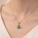Elegant gold necklace featuring a planetary pendant with a star and blue globe, perfect for science enthusiasts and stylish accessories.