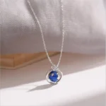 Elegant silver necklace featuring a spherical pendant with a detailed starry sky design in blue and gold, perfect for science and astronomy enthusiasts.