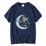 Navy blue T-shirt featuring a detailed graphic of an astronaut floating near a crescent moon with planets and stars in the background, perfect for space enthusiasts.