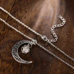Elegant silver moon and star pendant necklace with intricate filigree design, perfect for everyday wear or special occasions.