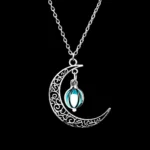 Elegant moon and star pendant necklace with intricate filigree design and a dangling blue gemstone. Perfect for astrology lovers and unique jewelry enthusiasts.
