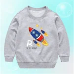Rocket sweatshirt with a colorful cartoon rocket ship, stars, and the letter "R" with the phrase "R is for taller!" on a light gray background.