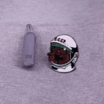 Wireless USB flash drive and astronaut-themed enamel pin on fabric background.