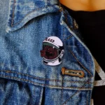 NASA-themed enamel pin with a black bear wearing an astronaut helmet, featuring the letters "CCCP" on the helmet.