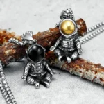 Silver astronaut pendant necklace featuring two astronaut charms with gold and black helmets, perfect for space enthusiasts and science lovers.