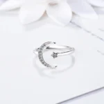 Elegant moon and star-shaped silver ring with embedded crystals, perfect for celestial-themed jewelry collections.
