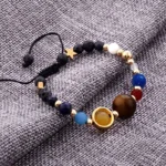Colorful beaded bracelet with a planetary design and gold accents, perfect for science-themed decor or educational purposes.