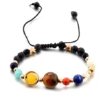 Vibrant beaded bracelet featuring various colorful beads, including a large brown bead, a yellow bead, and smaller blue, red, and cream beads, with an adjustable black cord.