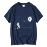 Navy blue T-shirt featuring a white astronaut playing golf in space with stars and a galaxy swirl background. Perfect for science and space enthusiasts.