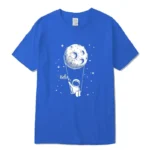 Bright blue T-shirt featuring a whimsical astronaut swinging from a moon with stars in the background, perfect for space enthusiasts and science lovers.