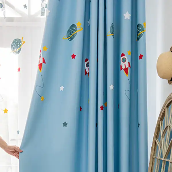 Bright blue kids' room curtain featuring colorful rockets, planets, and stars, perfect for a space-themed decor.