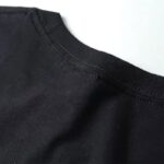 Close-up of a black crew neck t-shirt showing the neckline and fabric texture.