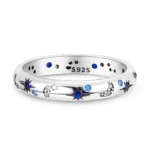 Elegant silver ring featuring star and moon motifs with blue and clear gemstones.