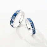Beautiful matching wedding rings with blue enamel and silver accents, featuring intricate wave patterns, perfect for symbolizing love and commitment.