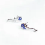 Elegant ocean wave earrings with silver finish and blue enamel accents, inspired by the sea's beauty. Perfect for ocean lovers and fashion enthusiasts.