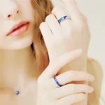 Elegant woman showcasing science-themed jewelry with blue accents, highlighting the beauty of science-inspired accessories.