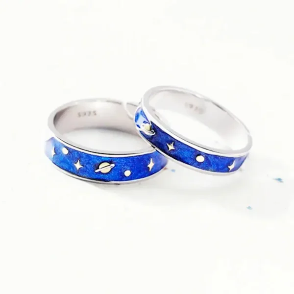 Silver rings with space-themed blue enamel design featuring planets, stars, and moons, perfect for science and astronomy enthusiasts.