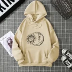 Beige hoodie featuring a black line art illustration of the sun and moon, symbolizing celestial harmony and balance. Perfect for casual wear and science-inspired fashion.