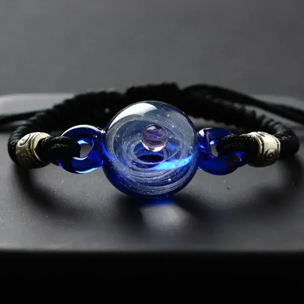 Elegant black cord bracelet featuring a central blue glass bead with swirling patterns and metallic accents, perfect for science-inspired jewelry enthusiasts.