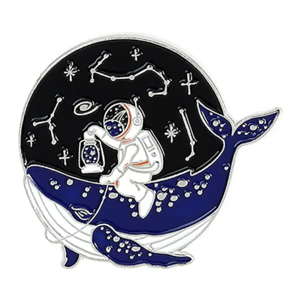 A whimsical enamel pin featuring a whale with an astronaut riding on its back, surrounded by constellations and stars, perfect for space-themed decor or educational accessories.