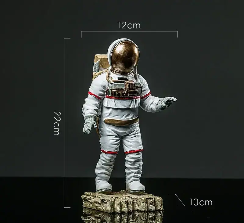 Astronaut Figurine on Rock Base Astronaut figurine with a gold helmet, white suit with red accents, standing on a textured rock base, measuring approximately 22cm tall, 12cm wide, and 10cm deep.