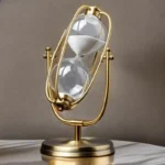 Stylish hourglass-shaped desk clock with a gold frame and white sand, combining modern design with a scientific aesthetic.