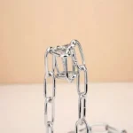 A close-up of a chain made of interconnected metal links, arranged in a creative and artistic manner.