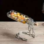 Bottle rocket sculpture with fruit pieces and chain stand.