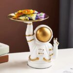 Adorable astronaut-themed candy dispenser with a gold helmet and white suit, designed for fun and decorative use in kitchens or playrooms.
