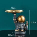 Unique astronaut-themed desk organizer with a gold dish on the helmet for holding small items, perfect for science enthusiasts and space lovers.