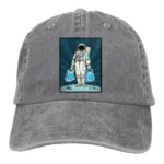 Gray baseball cap featuring a colorful astronaut illustration holding two blue shopping bags, set against a space-themed background. Perfect for science and space enthusiasts.