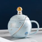 Cute space-themed mug featuring a white astronaut figure on the lid, galaxy illustrations, and the text "Space Walk" with a planet graphic, perfect for science and space enthusiasts.