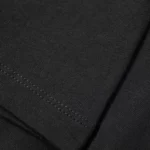 Black fabric with visible stitching detail, highlighting the texture and quality of the material.