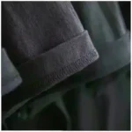 Black hoodie sleeve with detailed stitching and fabric texture.