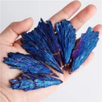 Hand holding vibrant blue malachite mineral specimens with layered, crystalline structure, ideal for educational science displays or decorative purposes.