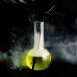 Beaker with yellow liquid and dry ice smoke, scientific experiment setup.