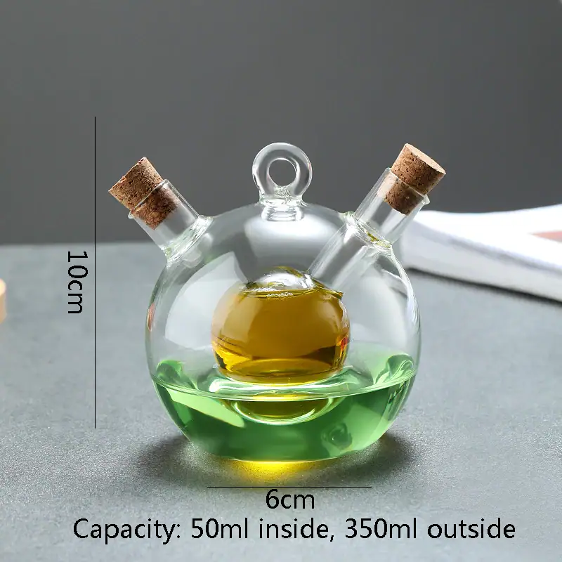 Small glass chemistry flask with three necks, filled with yellow and green liquids, featuring cork stoppers, on a gray background.