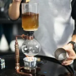 Laboratory distillation apparatus with glassware and copper components for science experiments.