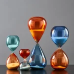 Brightly colored glass hourglasses in various sizes and shapes, perfect for science-themed decor and educational demonstrations.