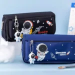 Two space-themed pencil cases featuring astronaut and rocket designs, with attached astronaut keychains, ideal for children’s school supplies.